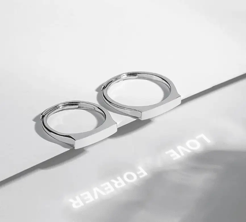 Луч фонаря выводит надпись «Forever» через линзу кольца