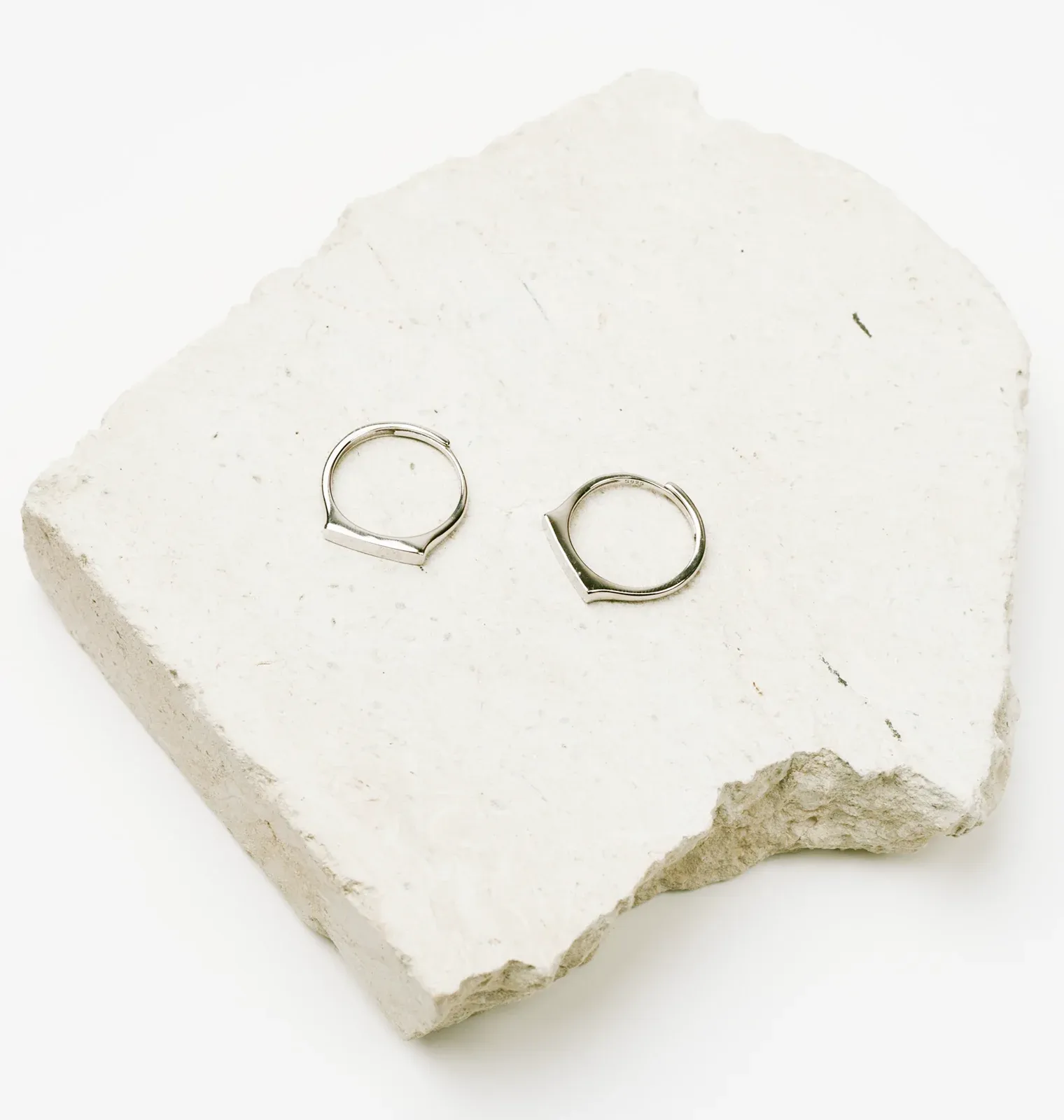 Изображение двух колец лежащих на белом камне